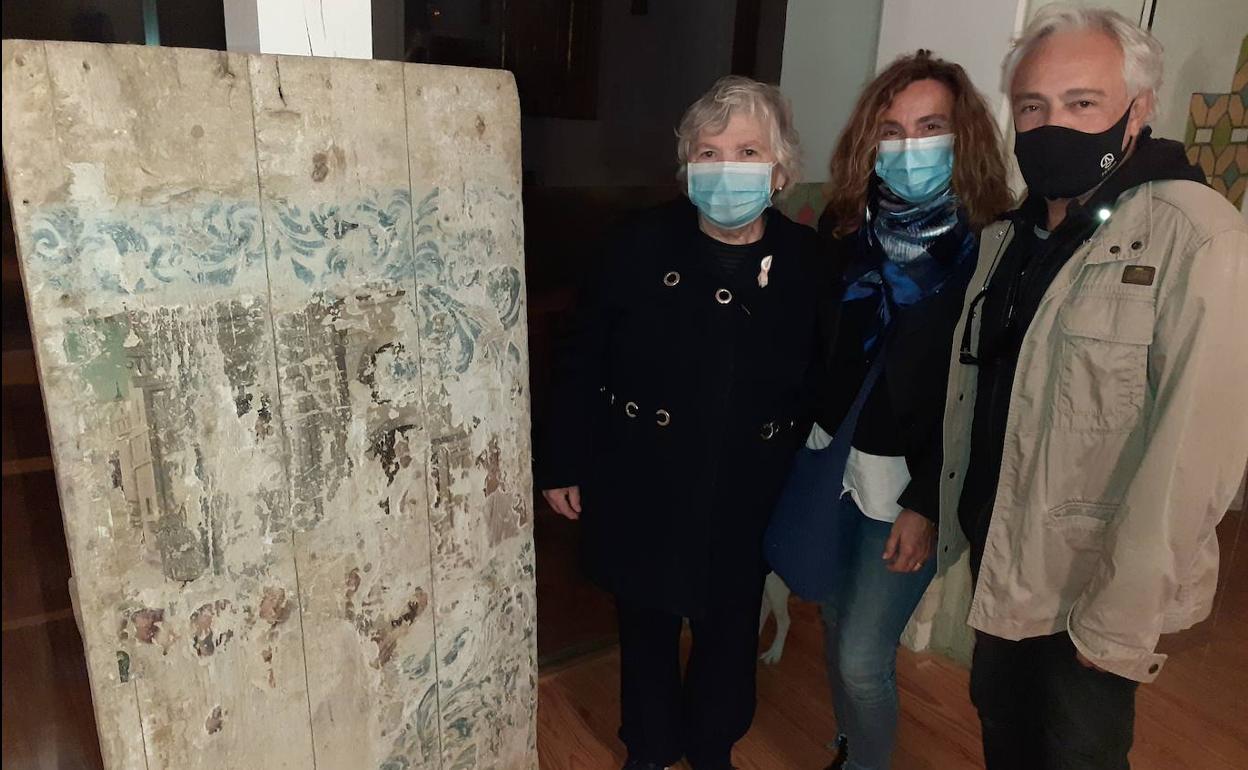 Conchita Rodríguez Brezmes, junto a la tabla que halló en la iglesia de San Pedro, acompañada por Carmen Sánchez y José Emilio Pelayo, amigos que la ayudaron a bajar la obra del campanario.