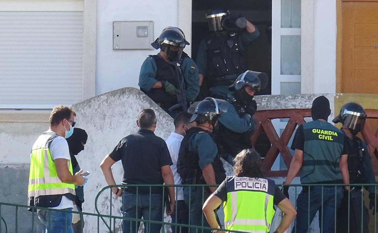 Los agentes conducen a 'Rafita' (de blanco) al registro de su domicilio en Girón. 