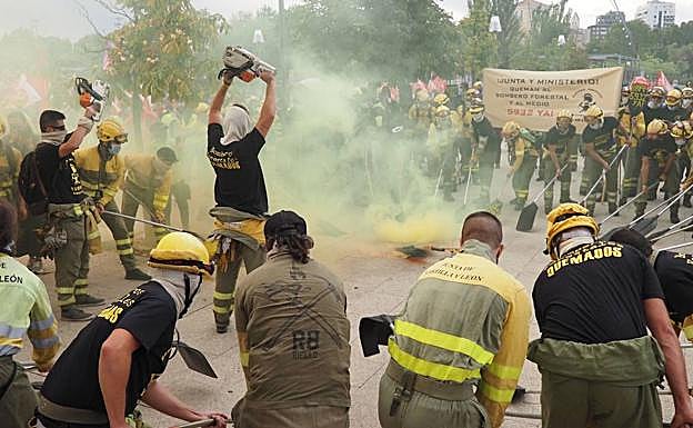 Los bomberos baten sus palas de exintinción ante las Cortes regionales durante su protesta en Valladolid. 