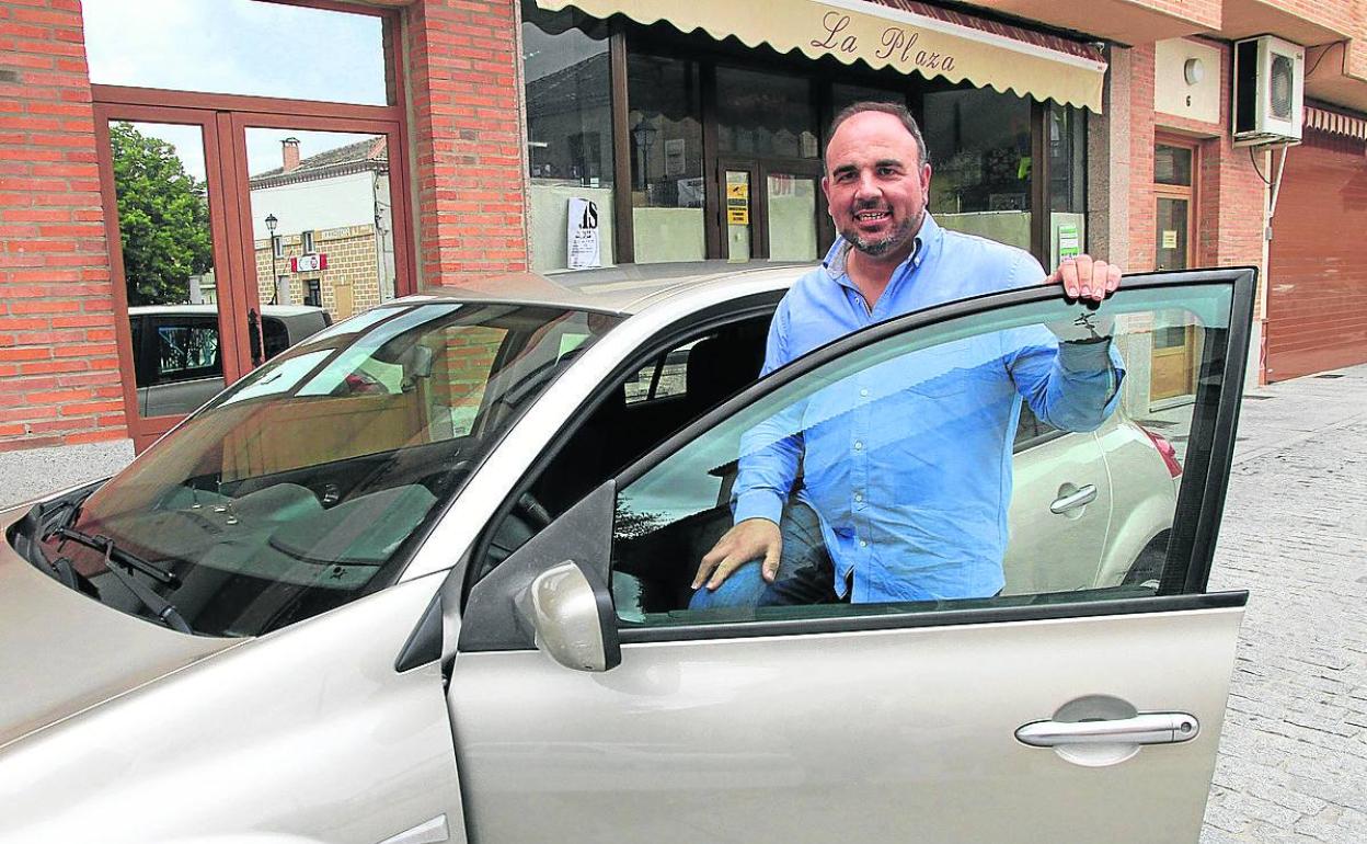 Francisco Javier Martín posa junto al coche con el que se desplaza de un pueblo a otro. 