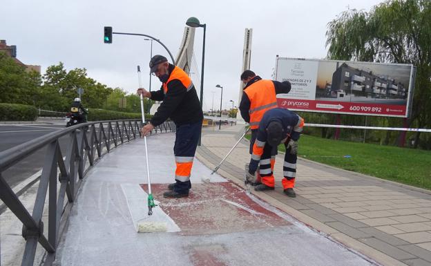 Imagen principal - Los operarios pintan el carril bici de la avenida de Zamora. Debajo, el nuevo tramo y, a la derecha, el tramo cortado del puente de Hispanoamérica. 