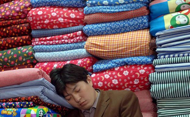 Un tendero se echa una siesta en China.