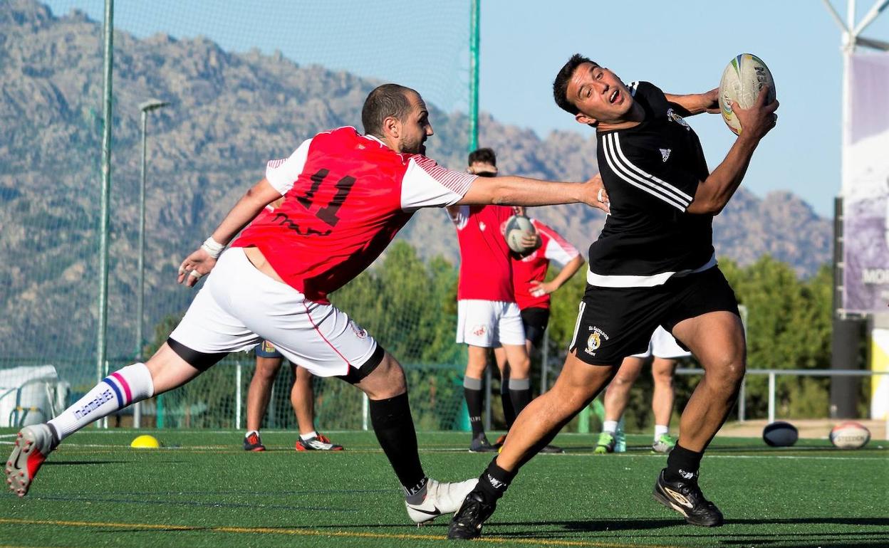 Un jugador de la sección de Touch de El Salvador intenta evitar el toque de un rival