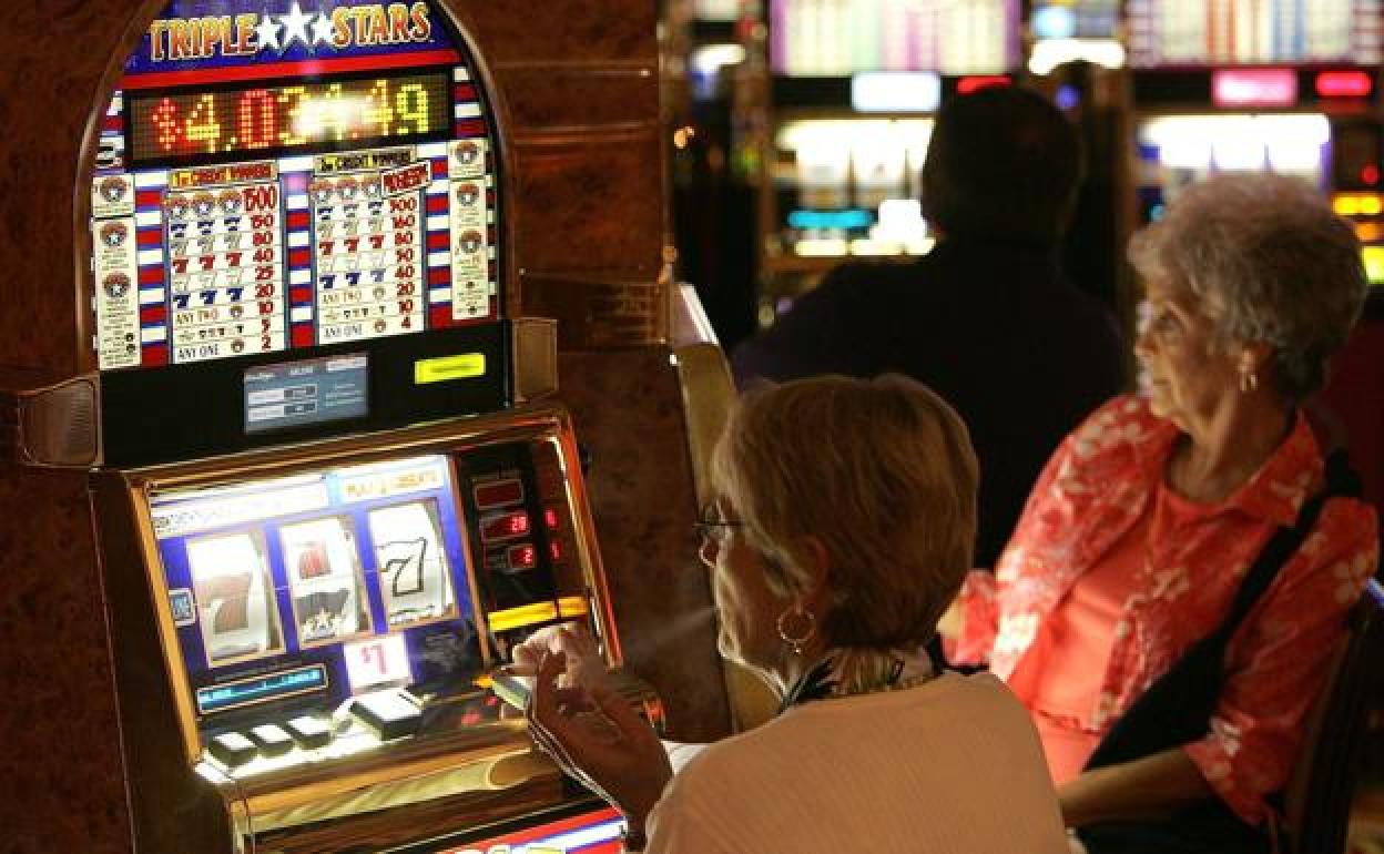 Dos mujeres juegan en las tragaperras. 