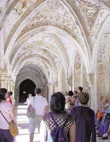 Imagen secundaria 2 - Arriba, visita en Bodegas Protos de Peñafie. Abajo lechazo asado y turistas en el claustro del Monasterio de Santa María de Valbuena. 