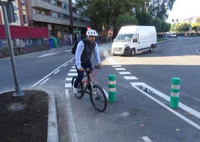 Imagen secundaria 1 - Un coche y un autobús procedente de la vía de servicio, en el cruce del carril bici. Debajo, a la izquierda, el bolardo del carril bici. A la derecha, un usuario espera para cruzar. 