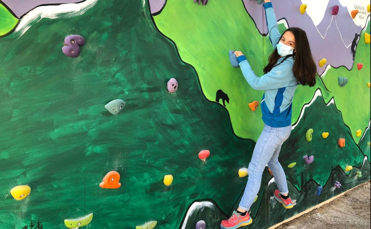 Una alumna practica escalada en el rocódromo. 