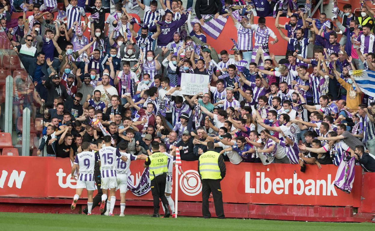 Los jugadores del Real Valladolid corren hacia la grada visitante para celebrar el gol de Aguado con la afición blanquivioleta desplazada a Gijón