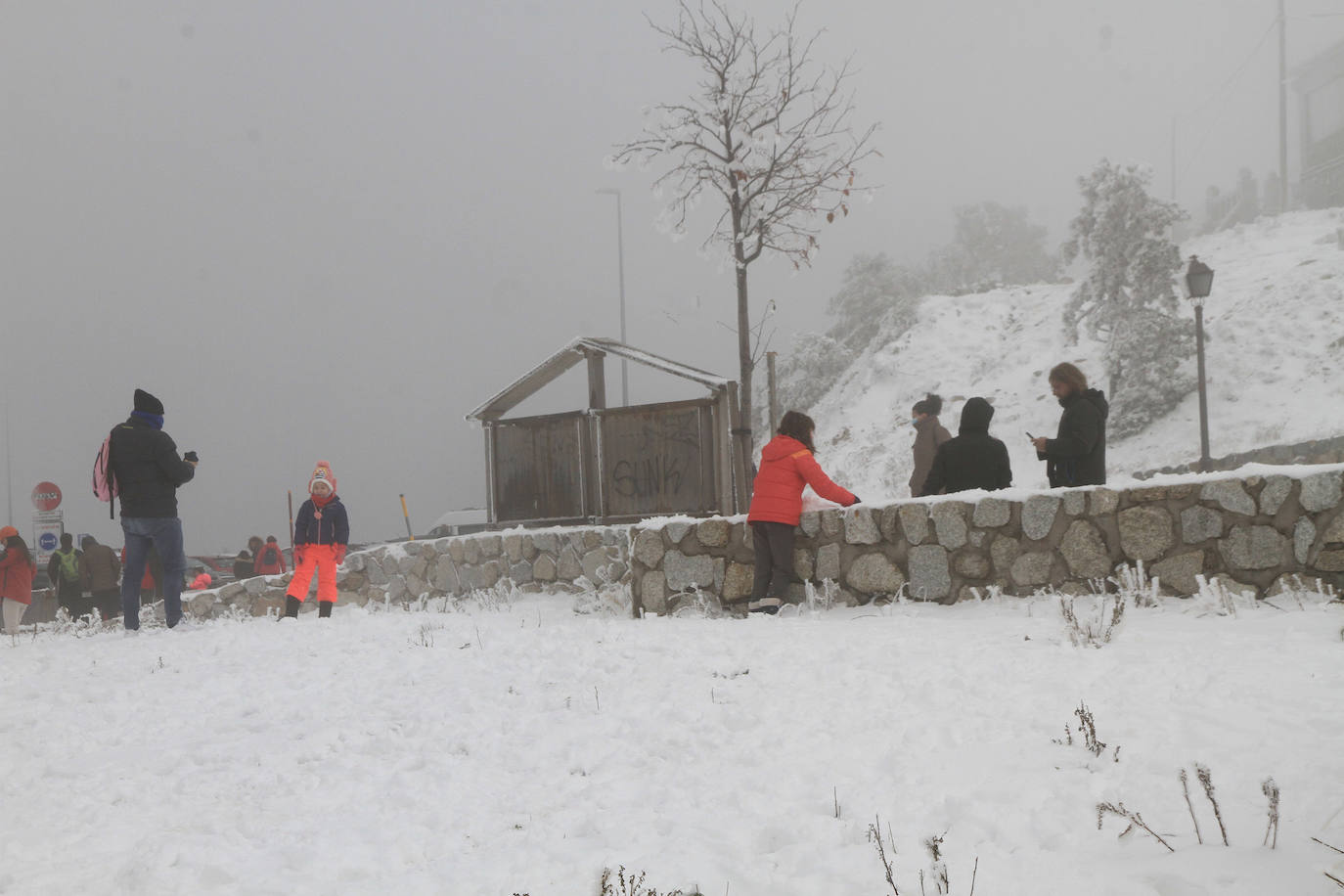 Turistas se hacen fotos en Navacerrada este sábado con las primera nevada. 