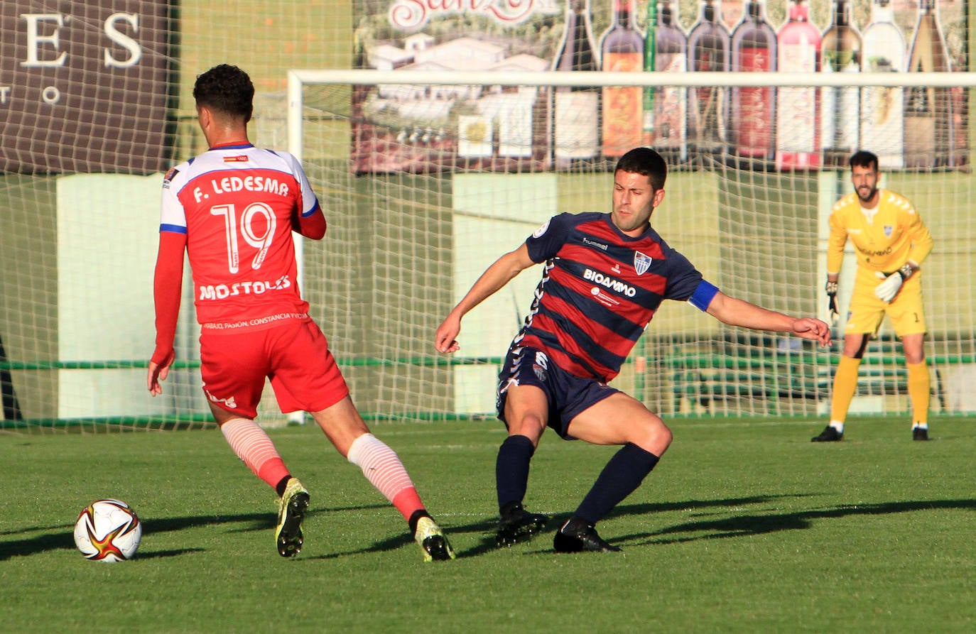Jugadores de la Gimnástica y del Móstoles forcejean en el saque de un balón parado. 