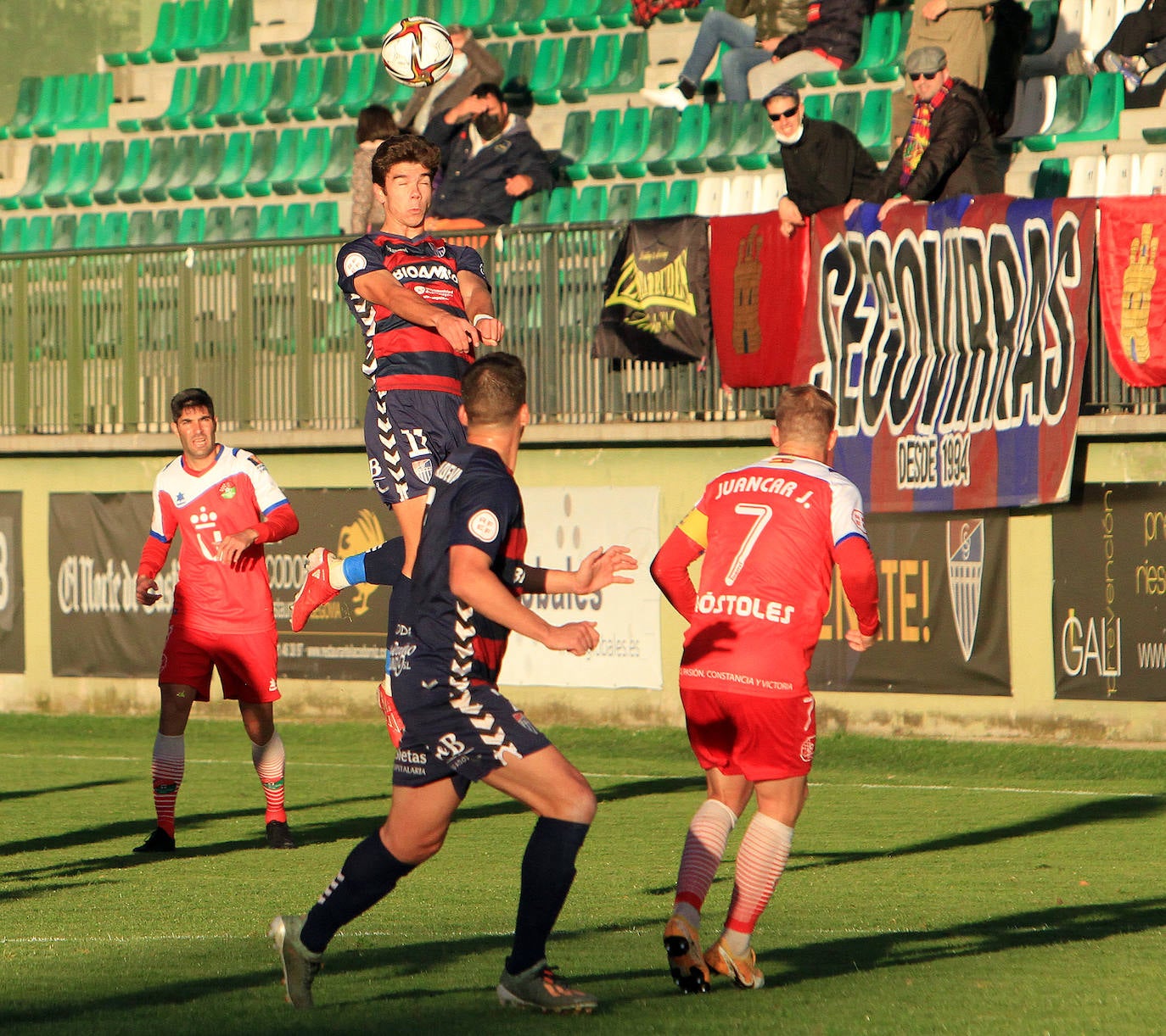 Jugadores de la Gimnástica y del Móstoles forcejean en el saque de un balón parado. 