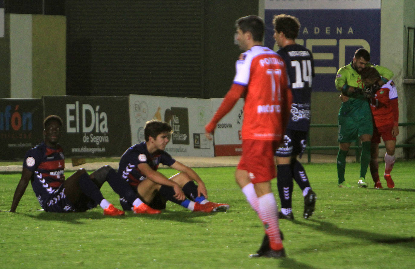 Jugadores de la Gimnástica y del Móstoles forcejean en el saque de un balón parado. 