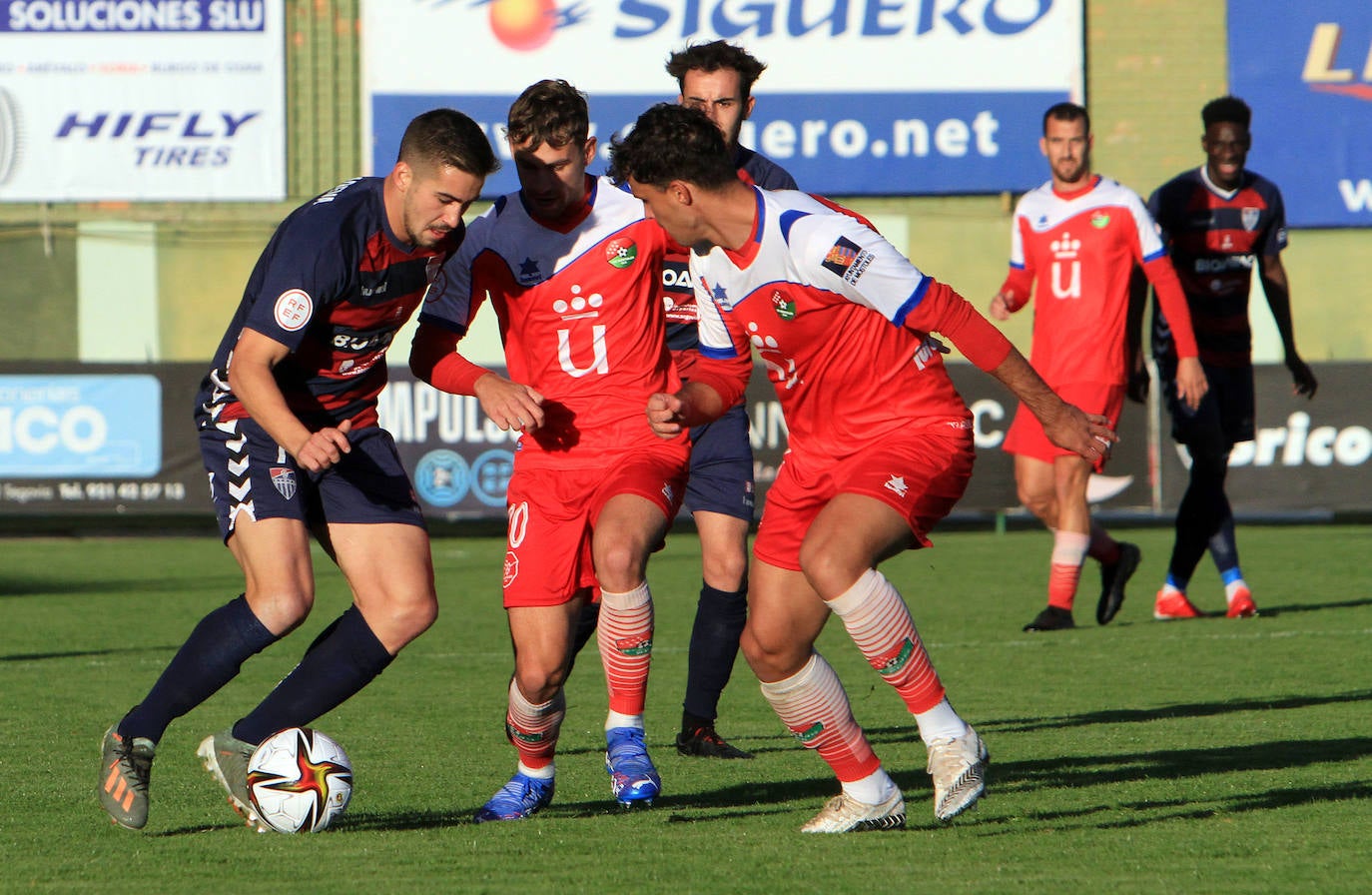 Jugadores de la Gimnástica y del Móstoles forcejean en el saque de un balón parado. 