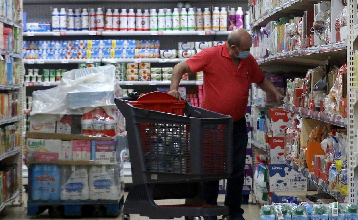 Un hombre compra leche en un supermercado.