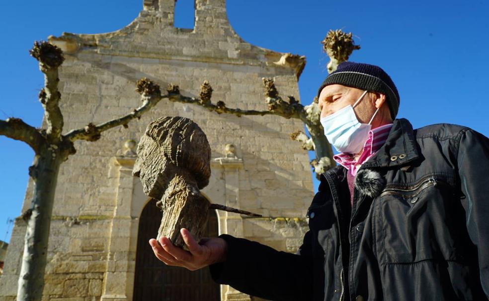 Nicolás Gimeno, vecino de Piña de Esgueva, sujeta la talla de madera que hallaron los Bomberos al retirar un nido en la ermita. 