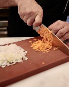 Imagen secundaria 2 - Lolo Astorga, chef de Los Ilustres, posa son sus lentejas que, como se ve abajo, llevan todos los sacramentos, además de verduras y pimentón.