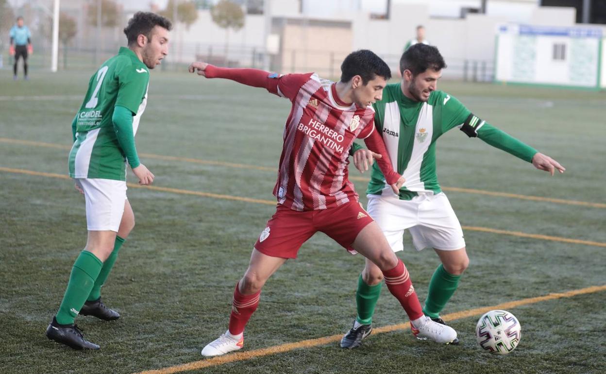 Dos jugadores verdiblancos pugnan con uno de la Ponfe por un balón dividido.