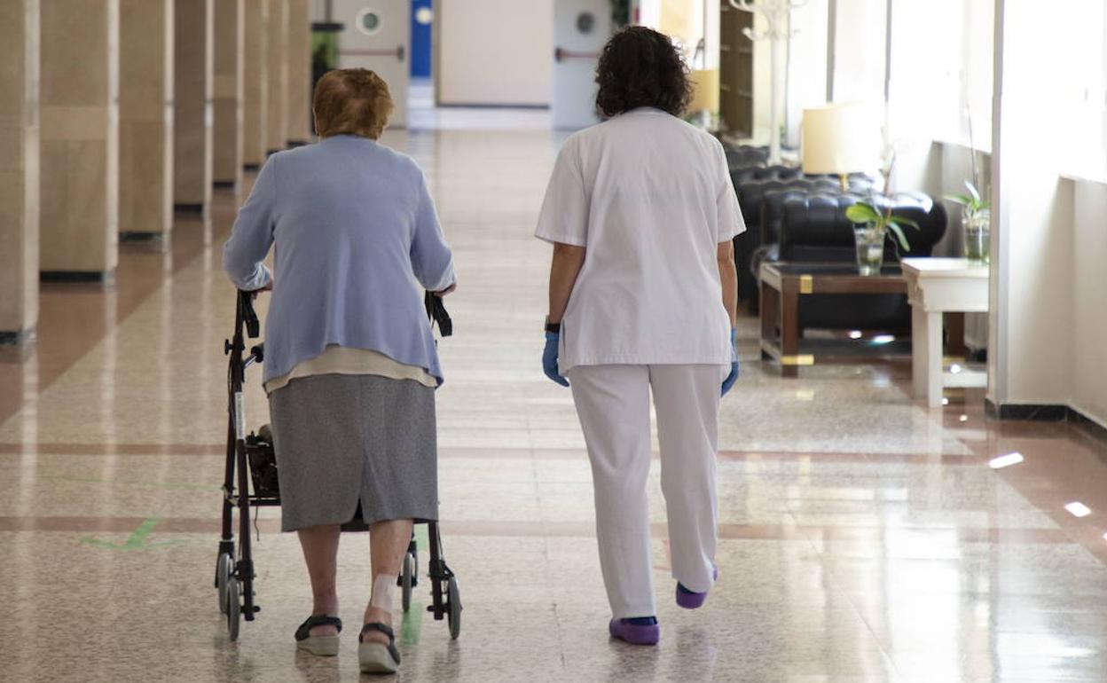 Dos mujeres avanzan por uno de los pasillos de una residencia de mayores en Valladolid. 