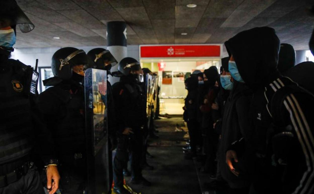 Varios mossos d'esquadra frente a manifestantes de una concentración que reivindica derechos civiles.