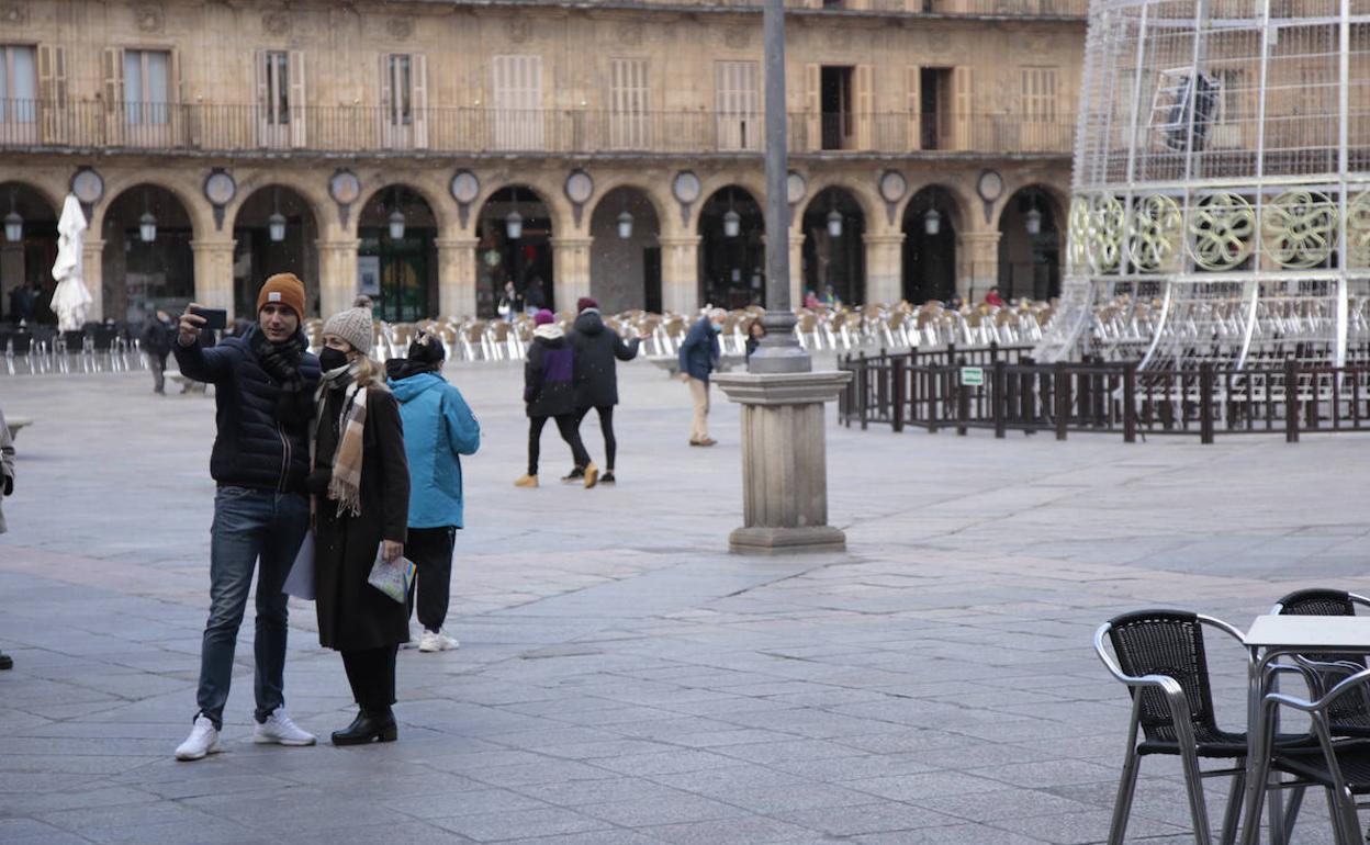 Una pareja de turistas se saca una foto en la Plaza Mayor de Salamanca. 