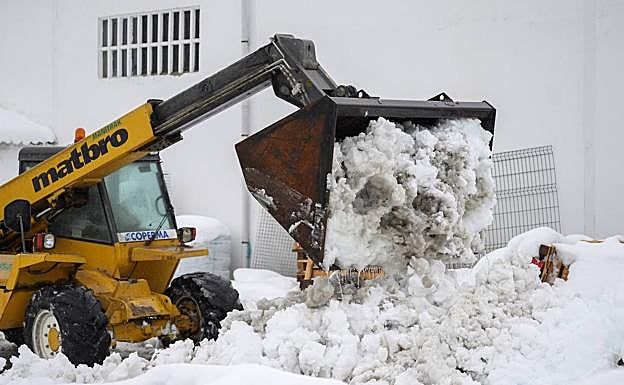 Una máquina recoge nieve. En el vídeo, una máquina quitanieves limpia una carretera de Palencia.
