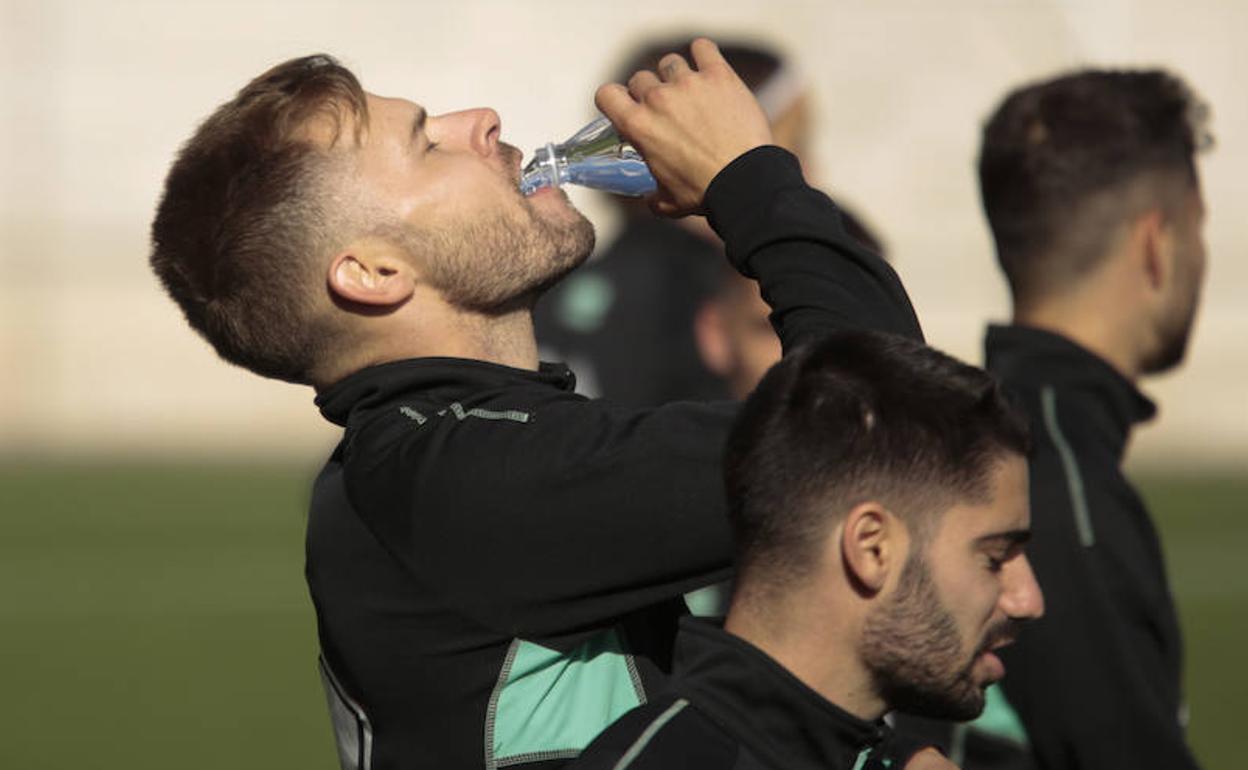 Mandi Sosa le pega un trago a una botella en presencia de Cris Montes durante un entrenamiento de Unionistas. 