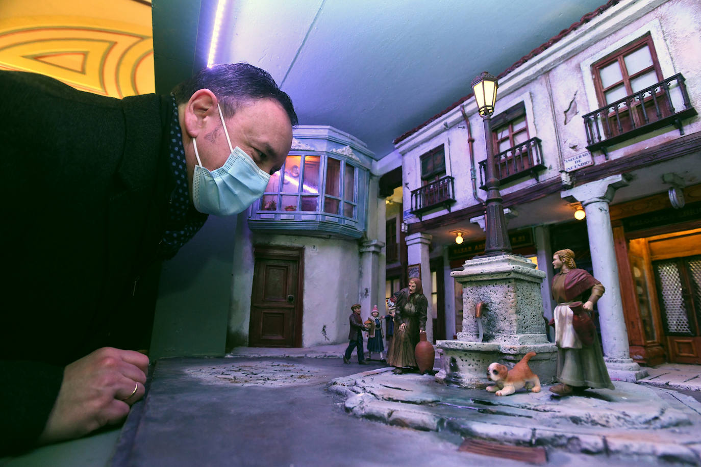 Un miembro de la cofradía observa los detalles de la recreación de la Plaza Fuente Dorada