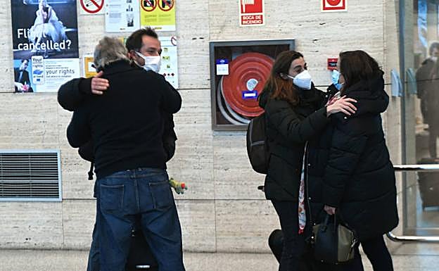 Dos pasajeros del vuelo de Turquía se abrazan con sus familiares tras aterrizar en el aeropuerto de Valladolid