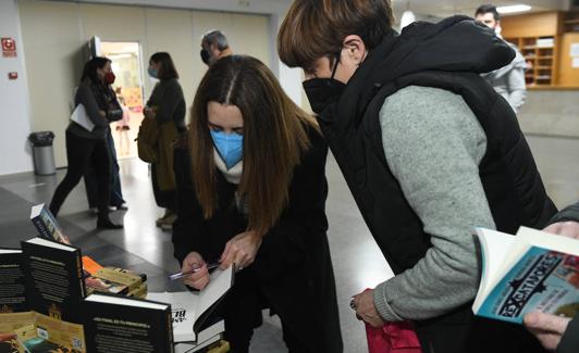 La escritora firma uno de sus libros antes de iniciar el coloquio literario.