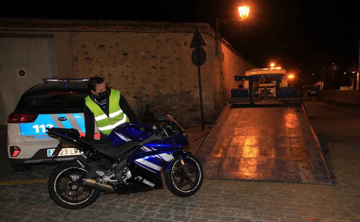 Un hombre retira la motocicleta accidentada para montarla en la grúa, este sábado, en la confluencia de Padre Claret con Coronel Rexach. 