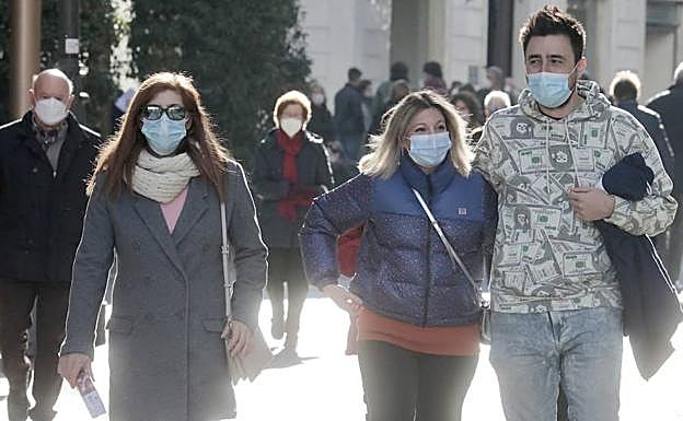 Varias personas caminan por el centro de Valladolid haciendo uso de la mascarilla.