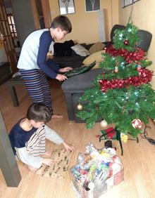 Imagen secundaria 2 - Los niños abren sus regalos navideños.