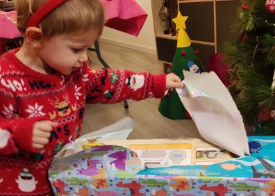 Imagen secundaria 1 - Los niños abren sus regalos navideños.