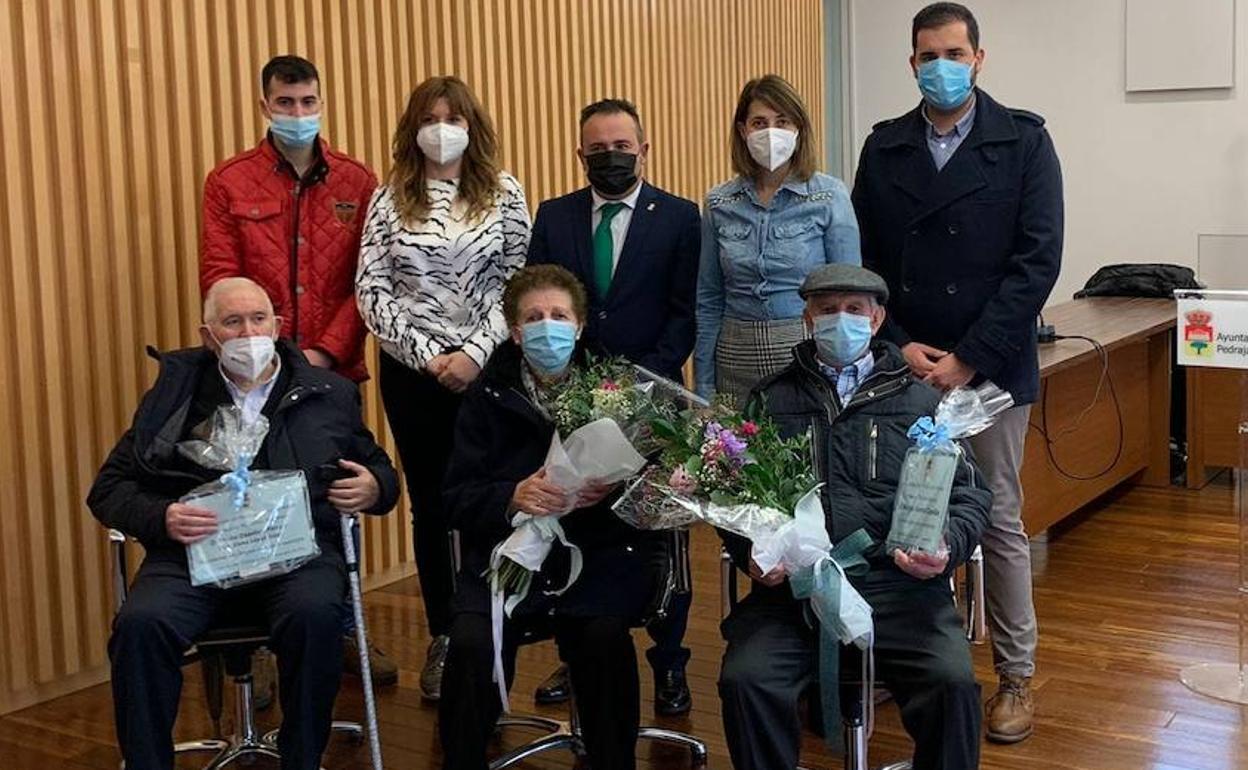 Los homenajeados posan con sus ramos de flores. 