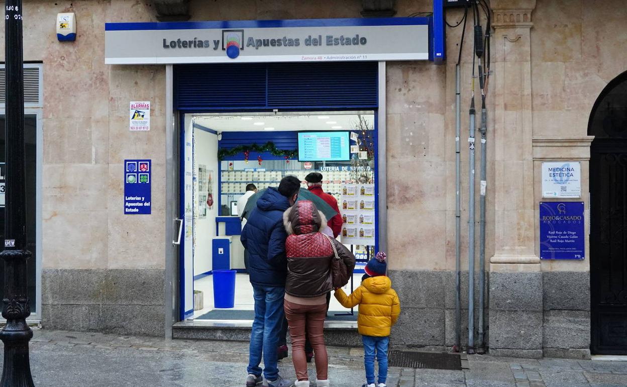 Clientes a la puerta de uan administración de Lotería en Salamanca.