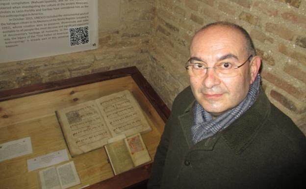 Juan Carlos Asensio posa en el Auditorio 'Carmelo Gómez' de Sahagún, ante un ejemplar de un Pasionario de 1582, que se expone con partituras del Oficio de Semana Santa.