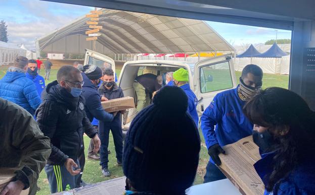 Imagen. Miembros de Turismoto descargan cajas frente a la gran carpa para los conciertos. 