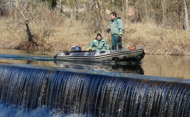 Dos agentes de la Guardia Civil buscan en el Duero.
