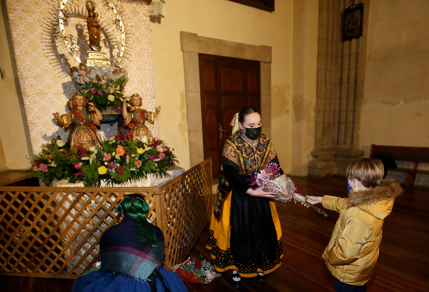 Los palentinos dejan sus flores a la Virgen la Calle en la iglesia de La Compañia