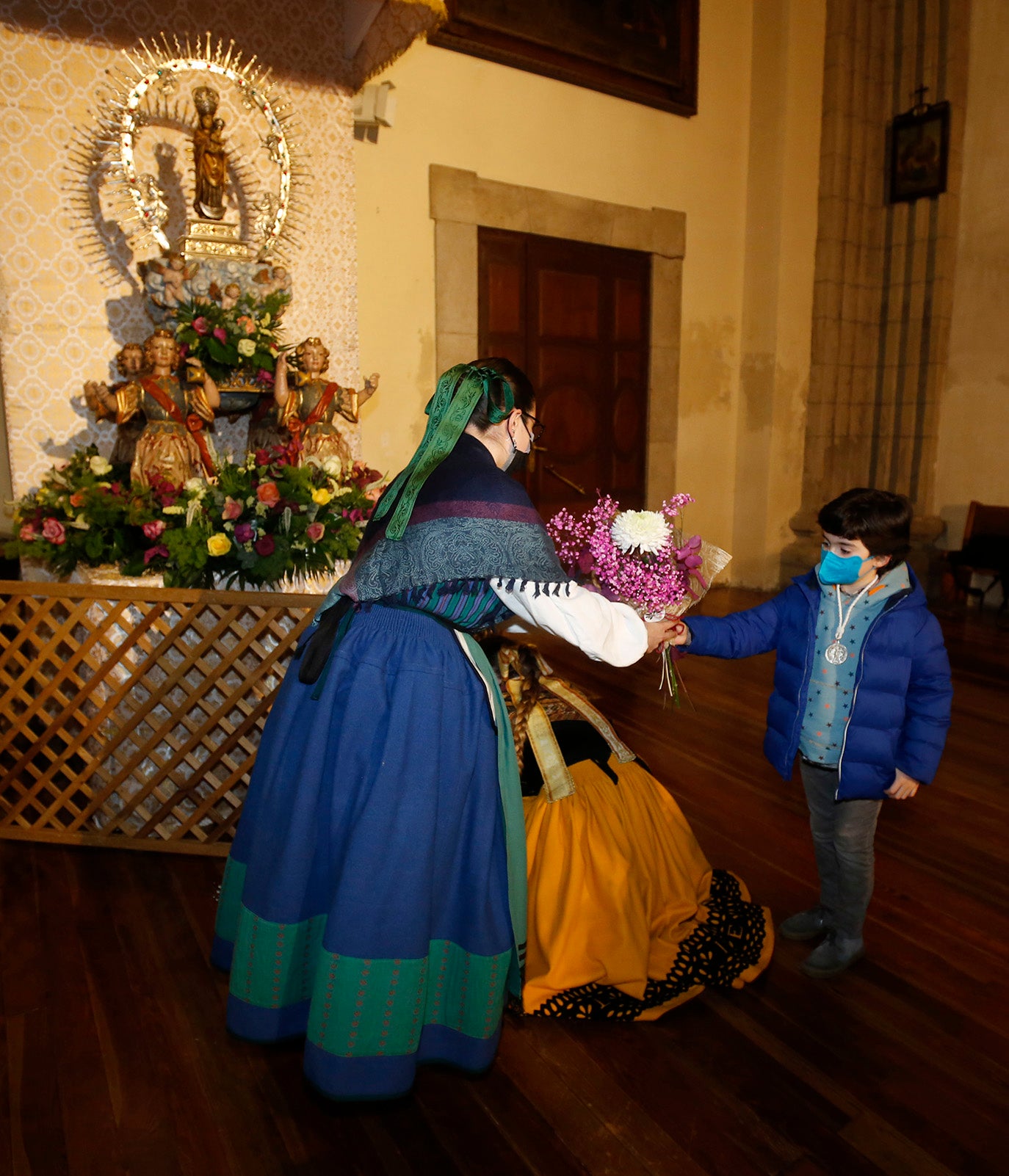 Los palentinos dejan sus flores a la Virgen la Calle en la iglesia de La Compañia