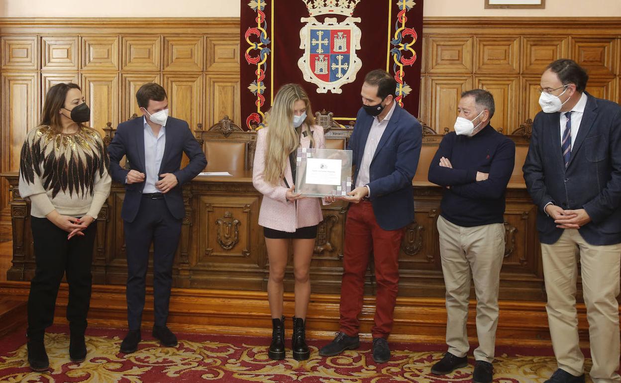 La atleta palentina Carla Gallardo recibe una placa de homenaje por parte de las autoridades. 