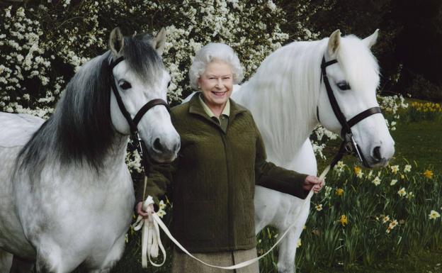 La Reina Iabel II, junto a dos de sus caballos.