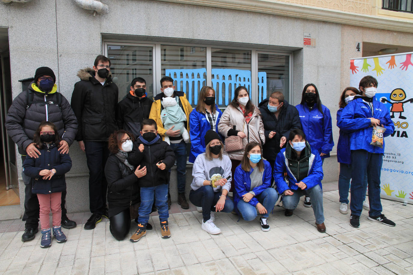 Miembros de Autismo Segovia, junto a la ilustradora Leticia Moreno, con uno de los ventanales pintados.