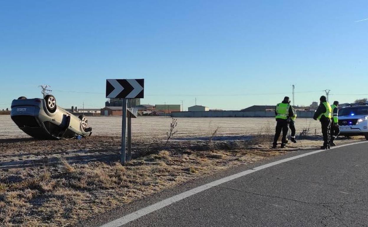 Agentes de la Guardia Civil, junto al vehículo accidentado a la entrada de Olombrada.