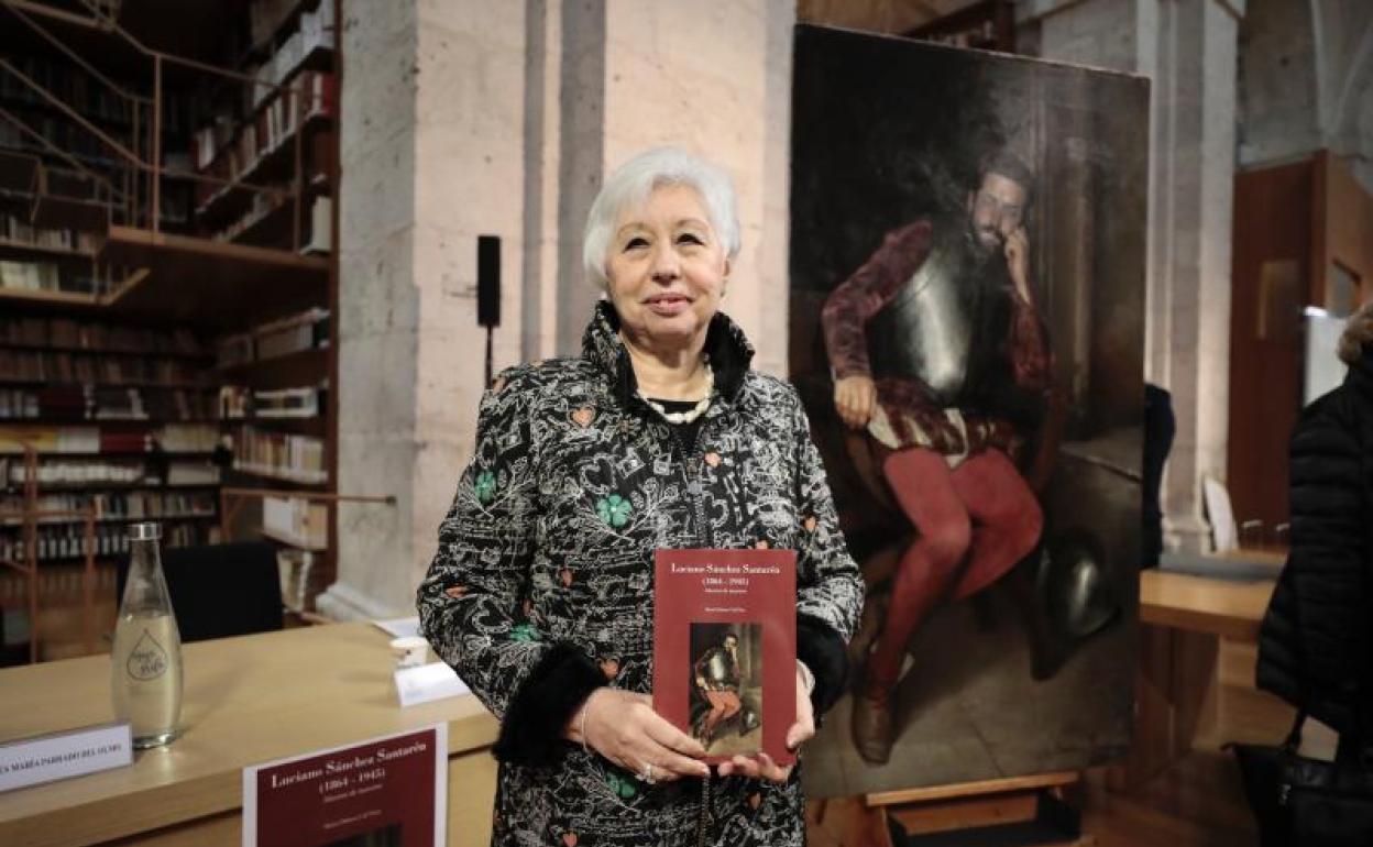 Dolores Cid, con su libro, y el cuadro restaurado. 