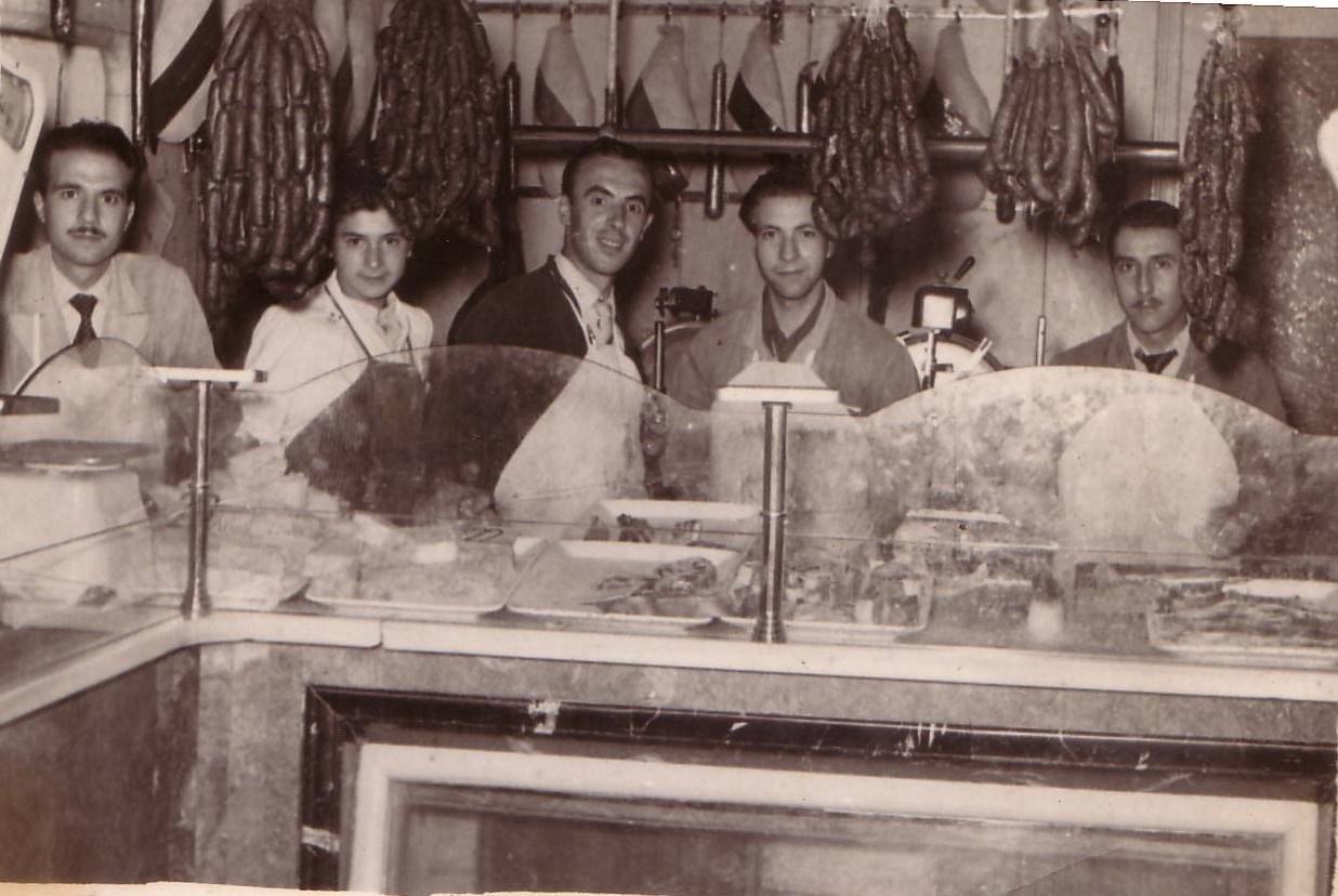 Juan Antonio Muñoz (primero por la izquierda) y Alberto Muñoz (cuarto), nietos de Pantaleón, junto a otros trabajadores en el mostrador del negocio en los años cincuenta del siglo pasado.