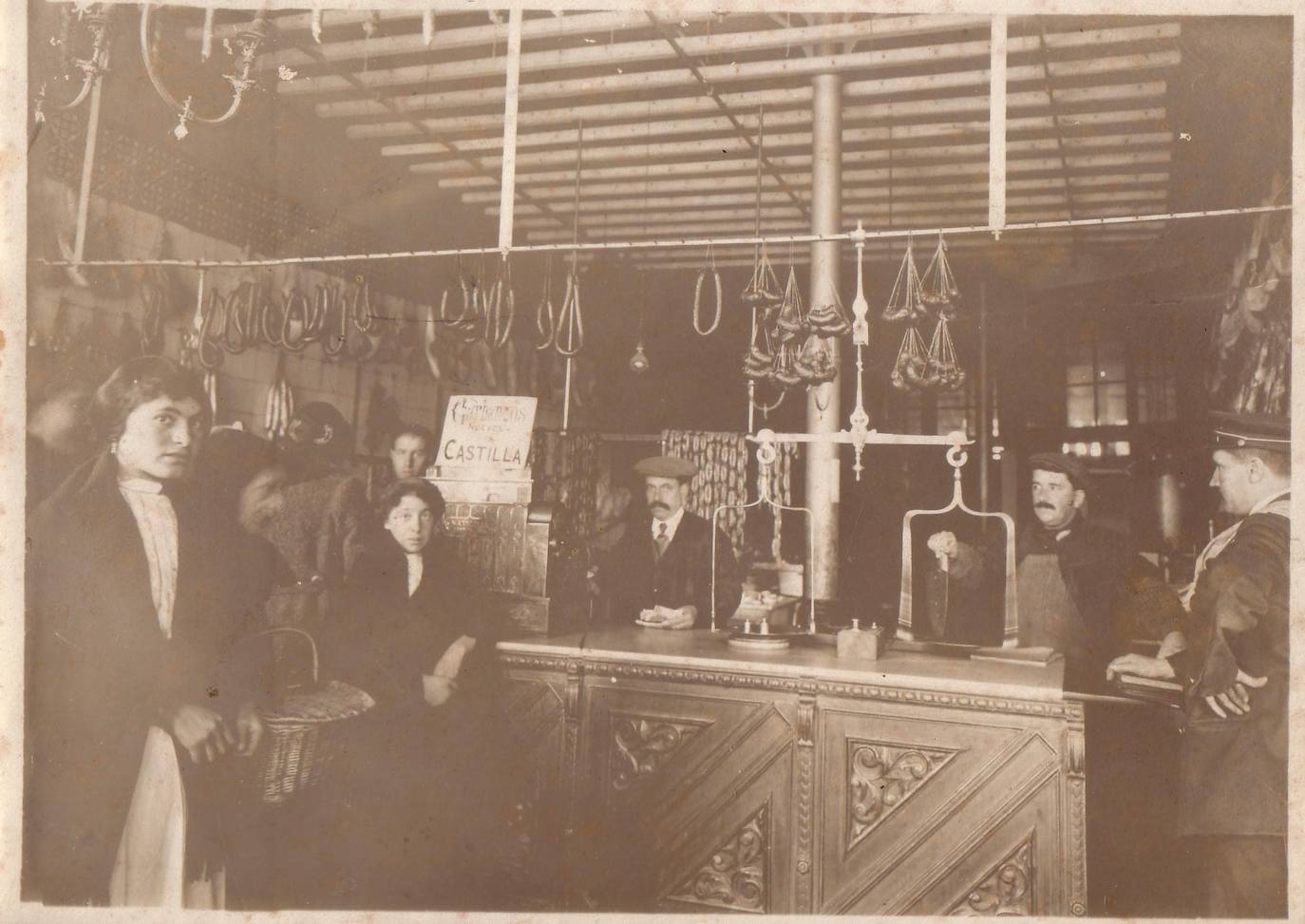 Pantaleón Muñoz, con gorra y corbata, en el mostrador de su negocio en el número 28 de la calle Ferrari, a finales del siglo XIX.