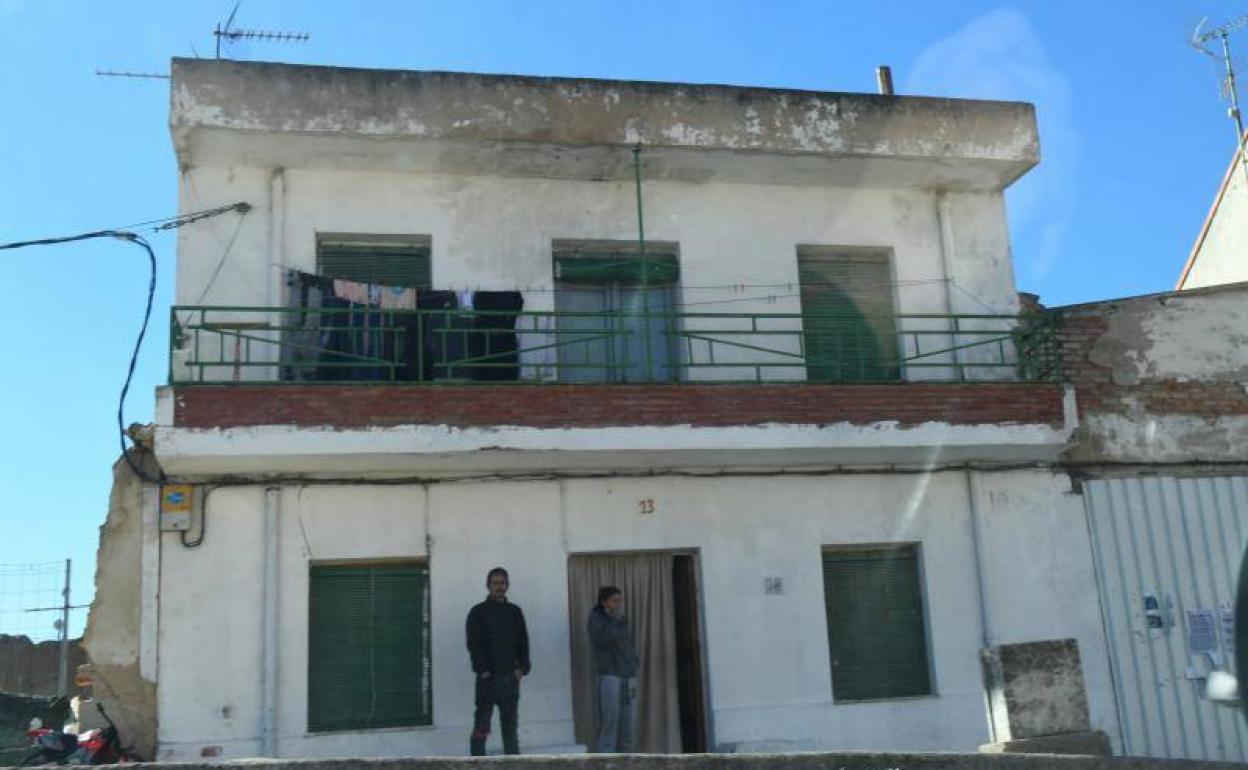 Dos personas salen a la puerta de la vivienda ocupada en la localidad de La Cistérniga . 