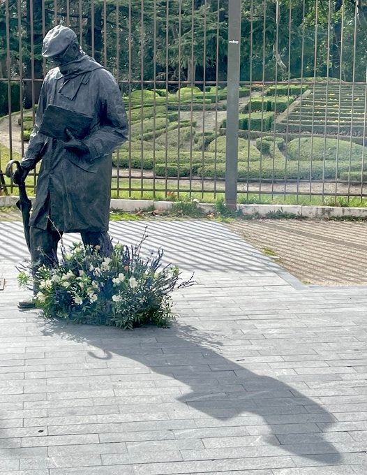 Escultura de Delibes en la puerta del Campo Grande con una corona de flores a los pies. 