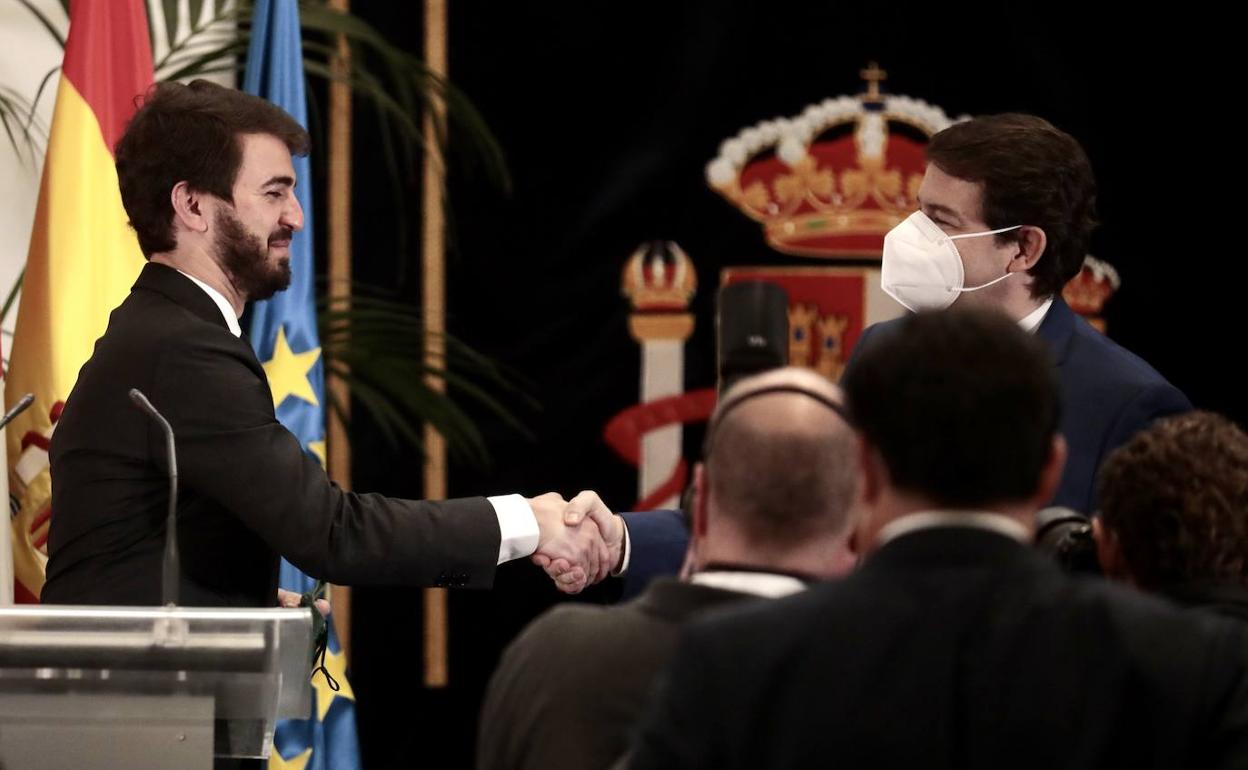 Juan García-Gallardo, futuro vicepresidente de Vox en la Junta, estrecha la mano a Fernández Mañueco tras firmar el acuerdo de gobierno.